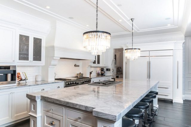 White kitchen with marble countertops and black bar stools (2)